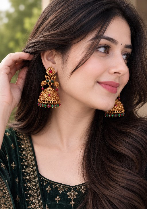 Alloy Kundan jhumka earrings with ruby red and emerald green stones and beaded drops worn by a woman