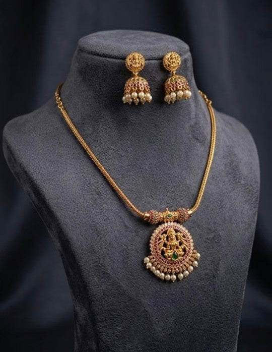 Lakshmi gold plated brass pendant necklace set with AD stones, ruby stone detailing and matching jhumka earrings, premium South Indian jewellery for women