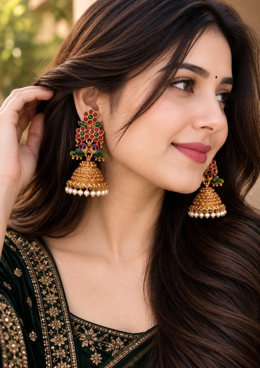 Mayura Royale Peacock Jhumka with ruby green stone detailing and white pearl drops worn by a woman