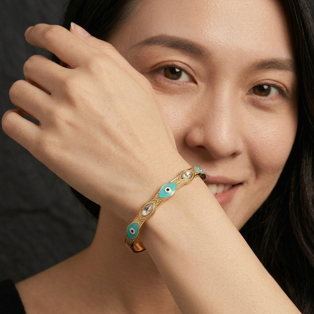 Model wearing the Tavisi Elara Charm Bracelet featuring a 22K gold plated stainless steel bracelet with turquoise charm and sparkling premium stones.