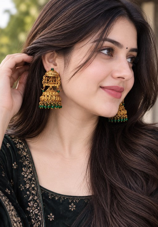 Traditional golden-tone alloy Lakshmi jhumka earrings with intricate temple-inspired detailing and green beads