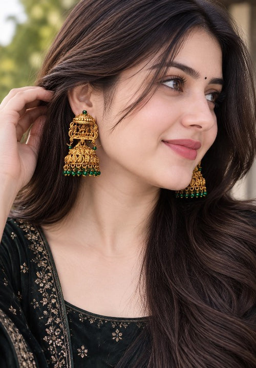 Traditional golden-tone alloy Lakshmi jhumka earrings with intricate temple-inspired detailing and green beads