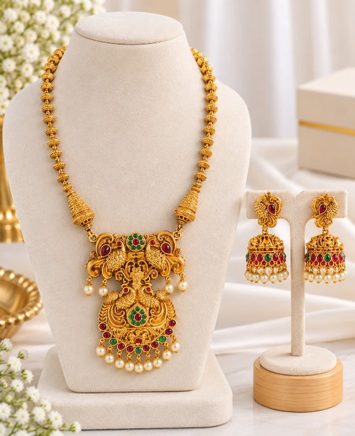 Aadhira antique high gold Haram with matching earrings, red green stones and pearl drops