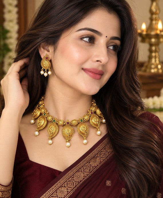 Woman wearing Aadhira premium brass antique high gold paisley mango necklace and earrings with saree