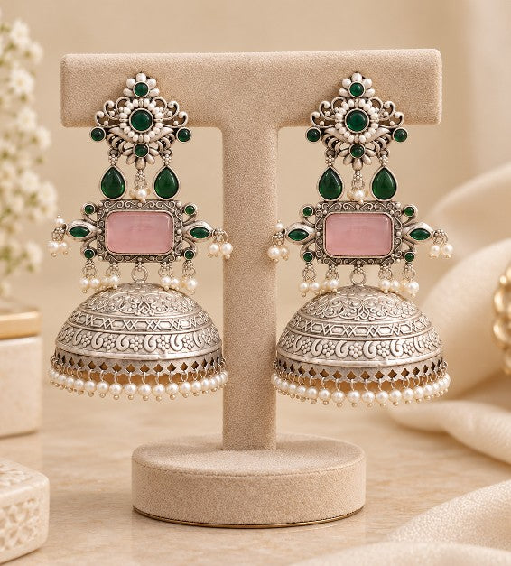 Close-up of Aaradhya green and rose pink jhumka earrings with pearl beads