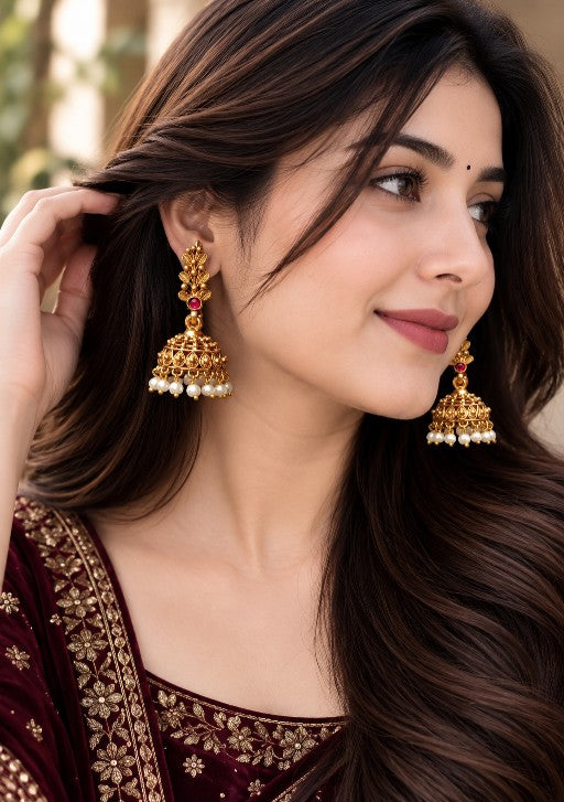 Woman wearing Anvika premium brass pearl jhumka earrings with pearl drops