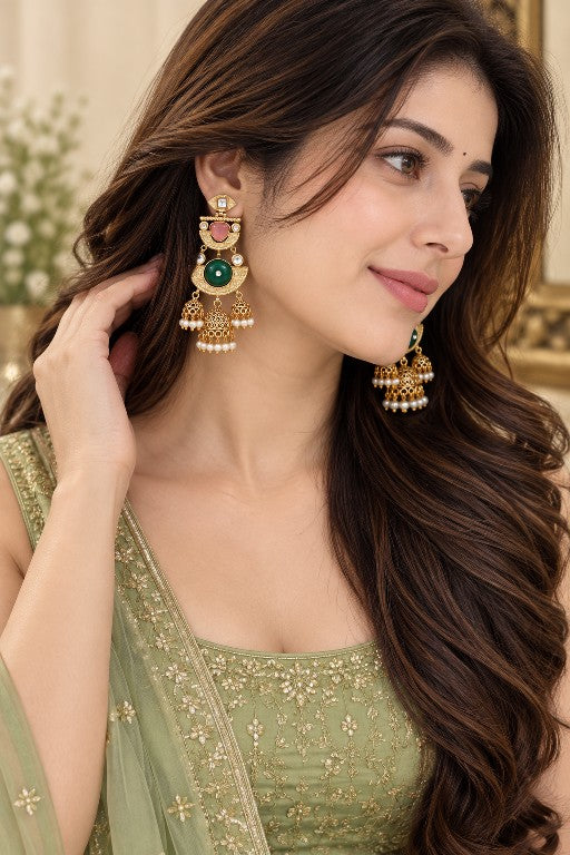 Woman wearing Avyara Premium ruby green AD jhumka earrings