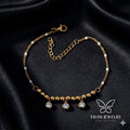 Gold Bead CZ Drop Charm Bracelet with triple crystal drops on white fabric - Tavisi Jewelry Collection