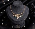 Gold Bow Charm Chain Pendant Necklace with Pearl and Stone Accents worn by model - Tavisi Jewelry Collection