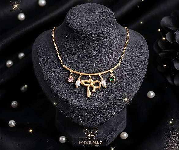 Gold Bow Charm Chain Pendant Necklace with Pearl and Stone Accents worn by model - Tavisi Jewelry Collection