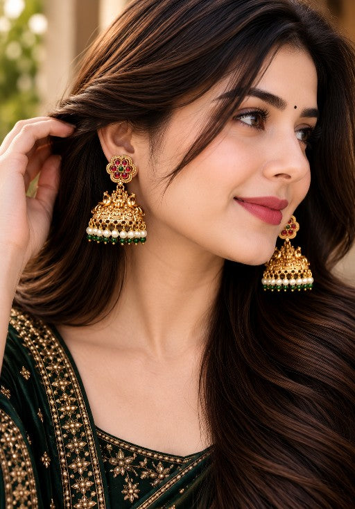Woman wearing Kavisha premium brass Lakshmi jhumka earrings with pearl and green bead drops