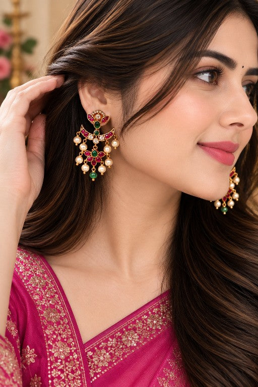 Woman wearing Madhulika premium brass floral pearl earrings with pink green detailing and pearl drops