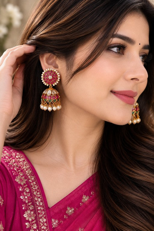 Woman wearing Meharika premium brass floral pearl jhumka earrings with pink green stones and pearl drops