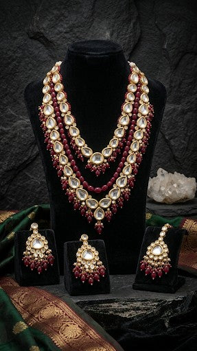 Sabyasachi inspired maroon Kundan bridal necklace set with matching earrings and maang tikka in premium brass.