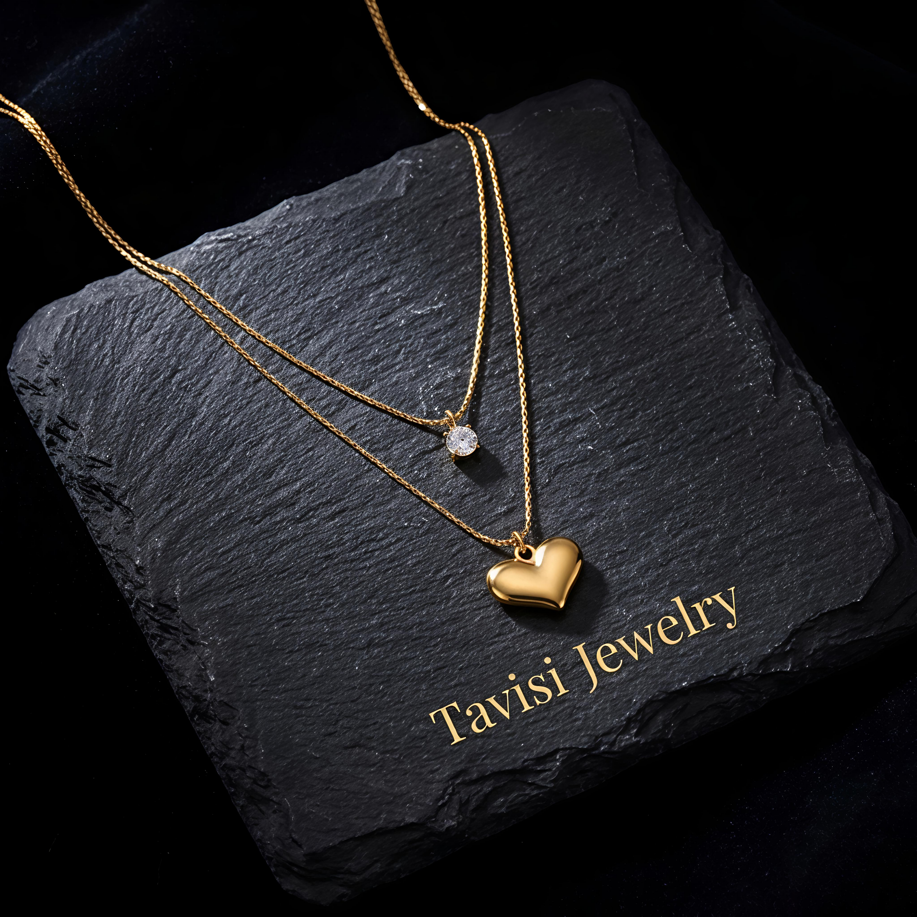 Close-up of Tavisi Amora Dual Layer Necklace showcasing a gold heart pendant and sparkling crystal accent with premium gold plated finish