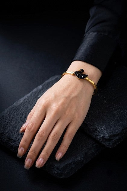 Woman wearing Tavisi Celina Swan Bracelet in 22K gold plated 316L stainless steel with black and white AD stones, anti-tarnish waterproof bracelet for women.