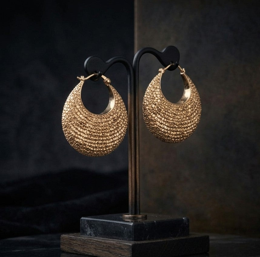 Tavisi Crescent Moon Pavé Hoop Earrings with sparkling AD & CZ stones displayed on a gold T-bar jewelry stand over black satin fabric.