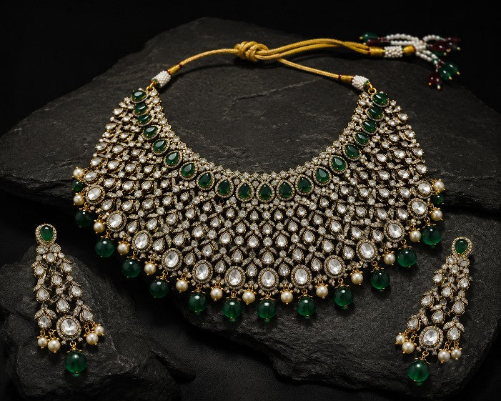 Close up of Tavisi handcrafted mehndi finish brass casting AD CZ bridal choker with green stones and pearl detailing
