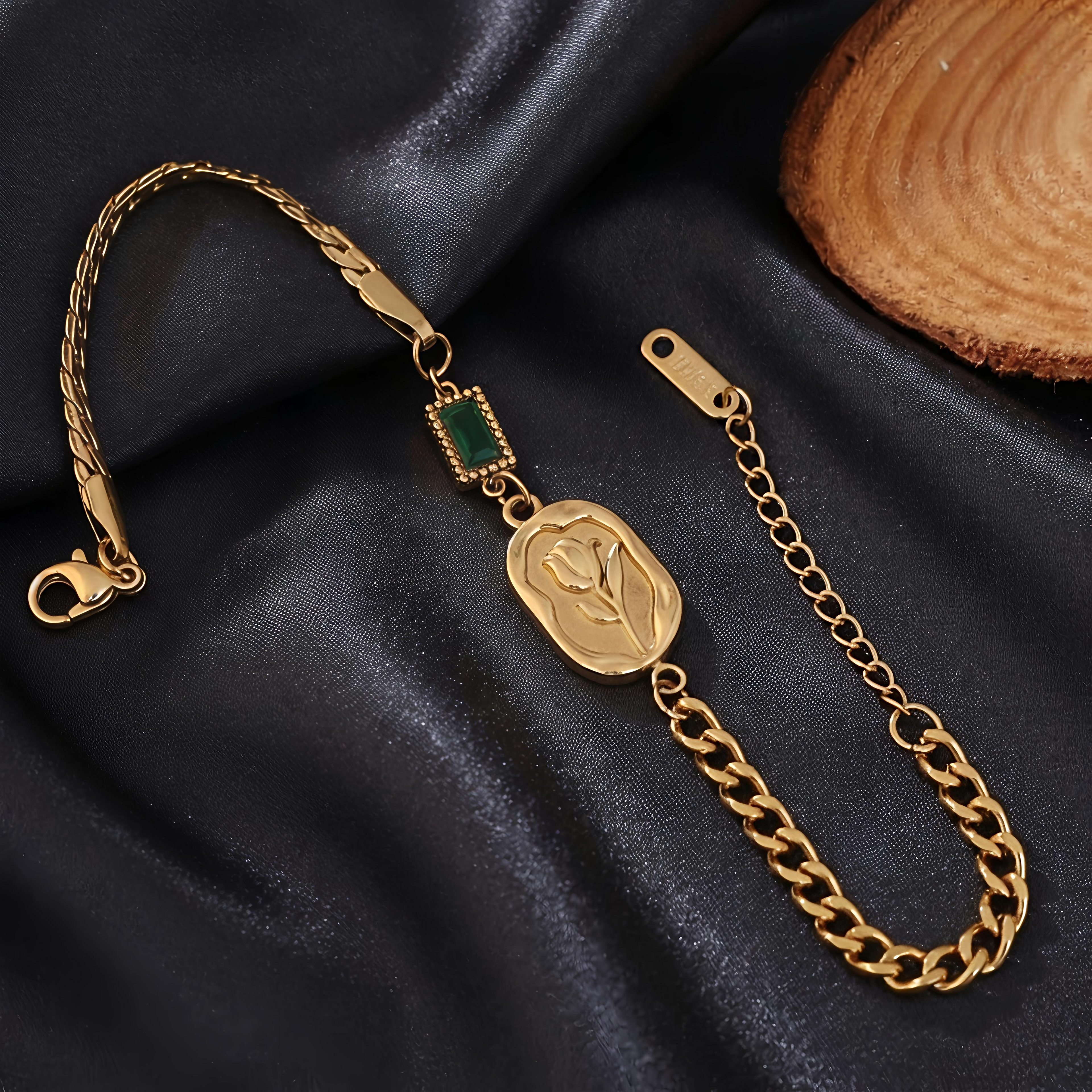 Close-up view of Tavisi Emerald Rose Chain Bracelet featuring an engraved rose motif, green accent detail, premium gold plated stainless steel and anti tarnish finish.