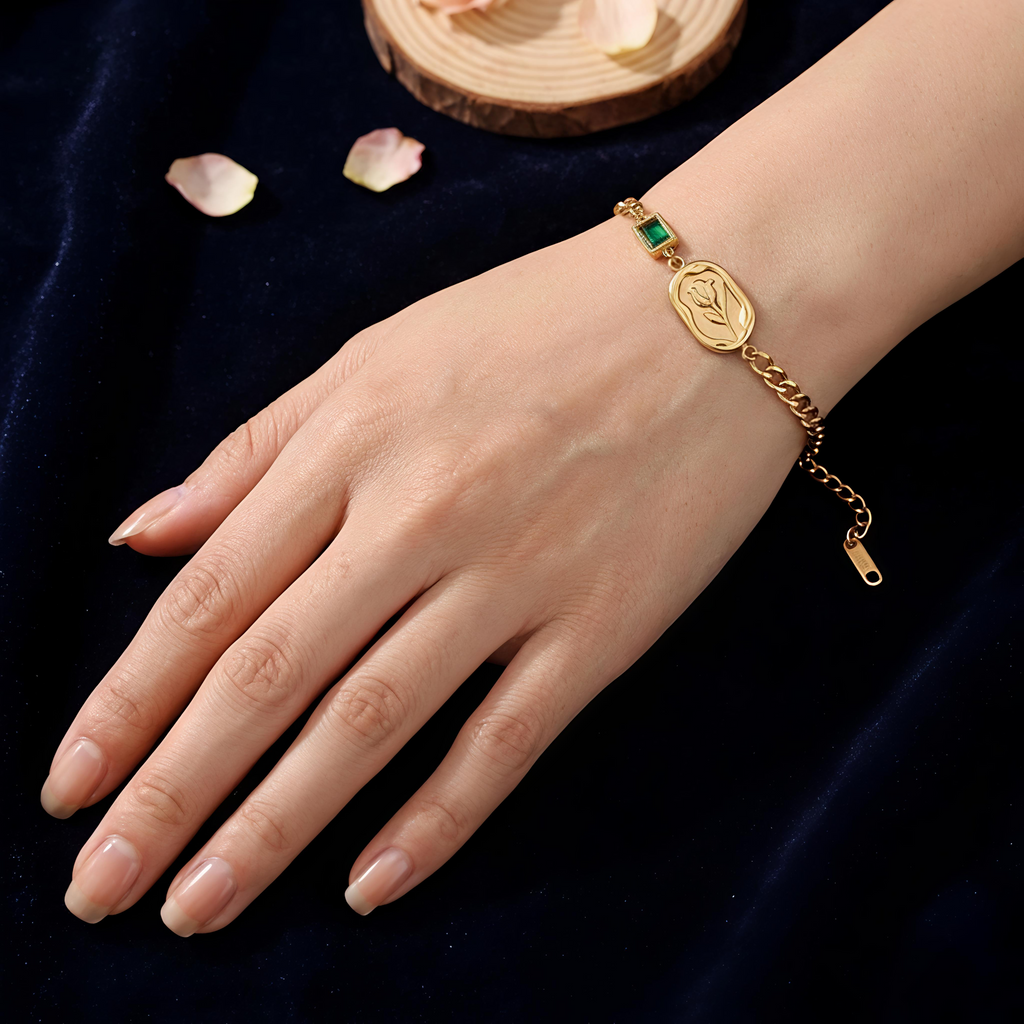 Detailed view of Tavisi Emerald Rose Chain Bracelet with rose engraving, emerald green accent, 22K gold plated 316L surgical stainless steel and waterproof anti tarnish coating.