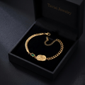 Tavisi Emerald Rose Chain Bracelet crafted in 316L surgical stainless steel with 22K gold plating, featuring a rose engraved centerpiece, green accent detail, waterproof anti tarnish finish and long lasting shine.
