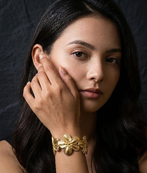 Woman wearing Tavisi Flora Luxe Gold Cuff Bracelet in 18K gold plated 316L surgical stainless steel with elegant floral design, anti-tarnish waterproof bracelet for women.