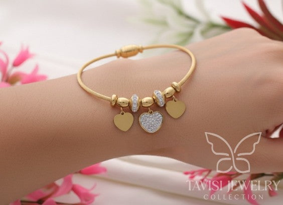 Detailed view of Tavisi Heart Charm Bracelet with AD stone centerpiece, 22K gold plated stainless steel and waterproof anti tarnish coating.