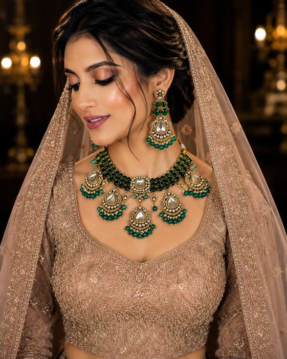 Tavisi Jardin long lasting premium bridal jewellery set with kundan stone, white CZ stones, emerald green AD stones, green beads, white pearls, brass casting and mehanti finish.