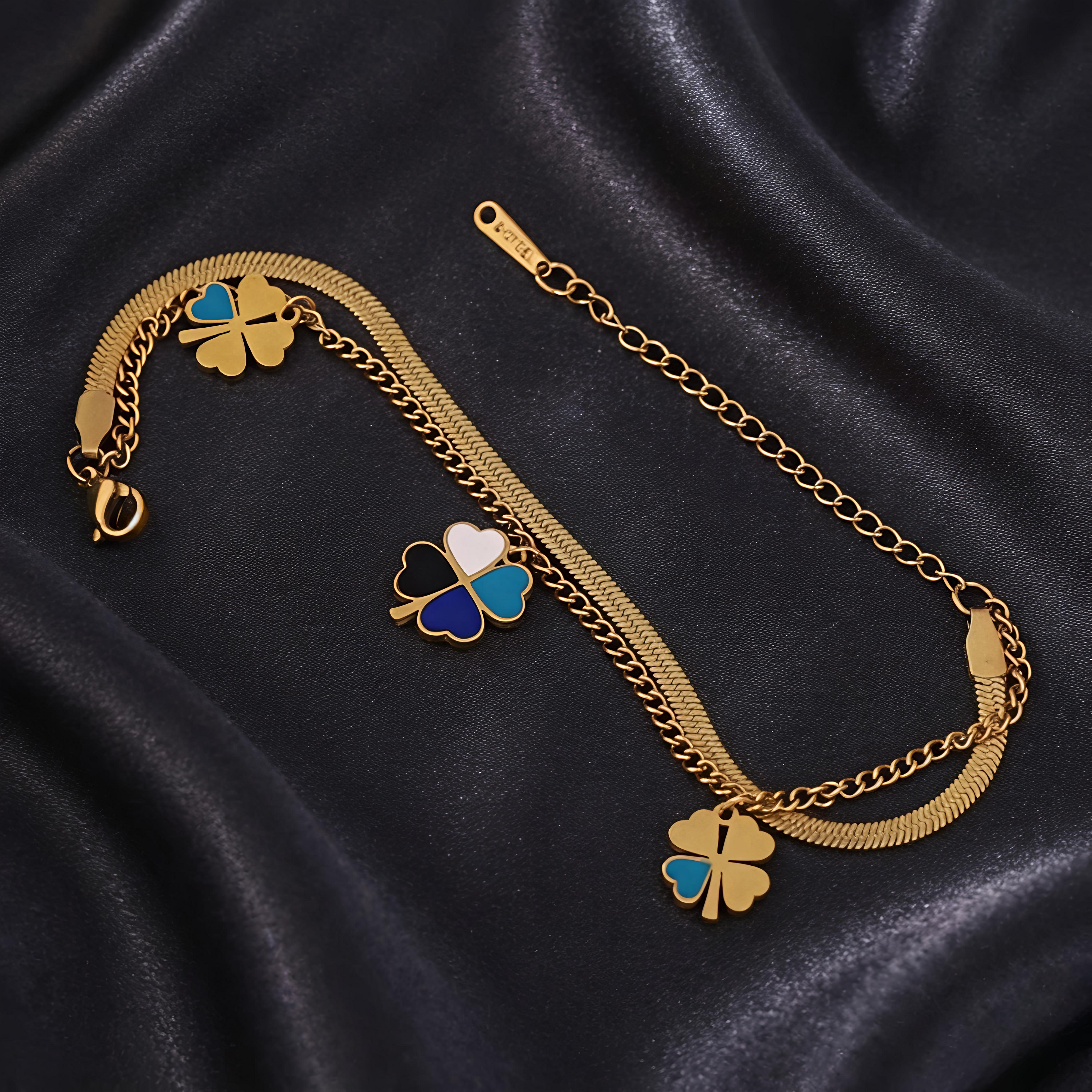 Close-up view of Tavisi Lucky Clover Charm Bracelet featuring enamel clover charms, dual chain detailing, 22K gold plated stainless steel and anti tarnish finish.