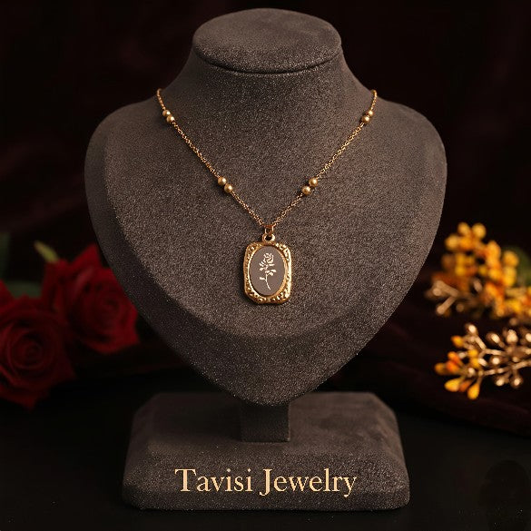 Tavisi Roselle Bloom Pendant Necklace displayed on a premium jewelry stand featuring an elegant rose engraved pendant with long lasting gold plated finish