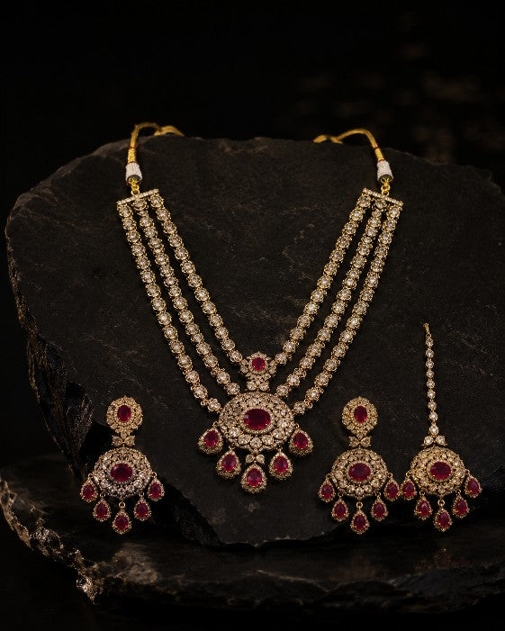 Close-up of Tavisi Ruby Majesty necklace with AD detailing, CZ stones, ruby pink stones and brass casting.
