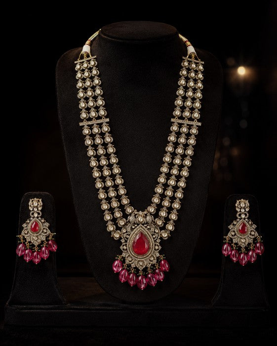 Tavisi Ruby Royale layered necklace set with AD stones, white CZ stones, ruby red stones, ruby beads, brass casting and mehanti color finish.