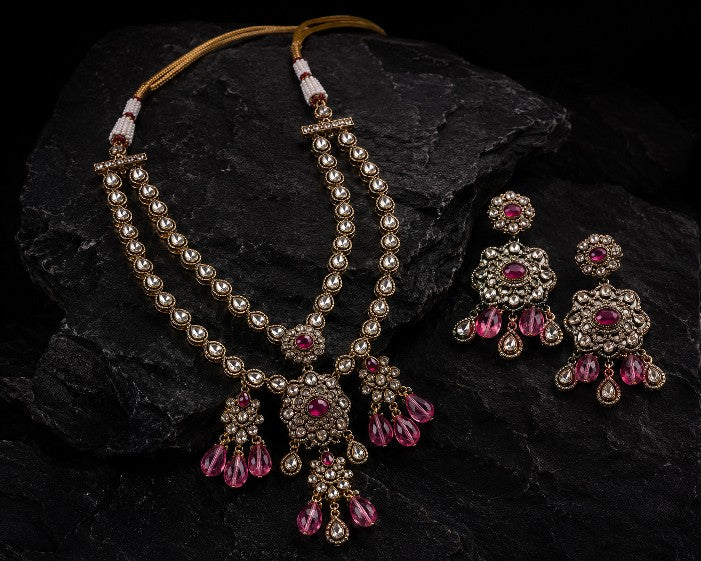 Close-up of Tavisi Ruby Noir layered necklace with white CZ stones, AD detailing, ruby pink beads and premium brass casting.