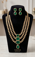 Front view of Tavisi Victorian three layer polki kundan necklace set with white stones and emerald green stones.